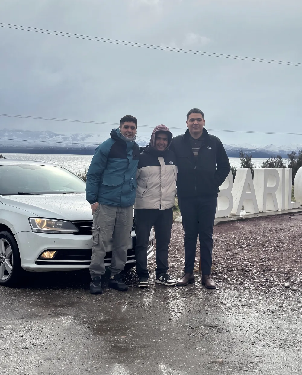 Entrega de un Volkswagen Vento blanco en Bariloche, Río Negro, frente al lago y el cartel de la ciudad